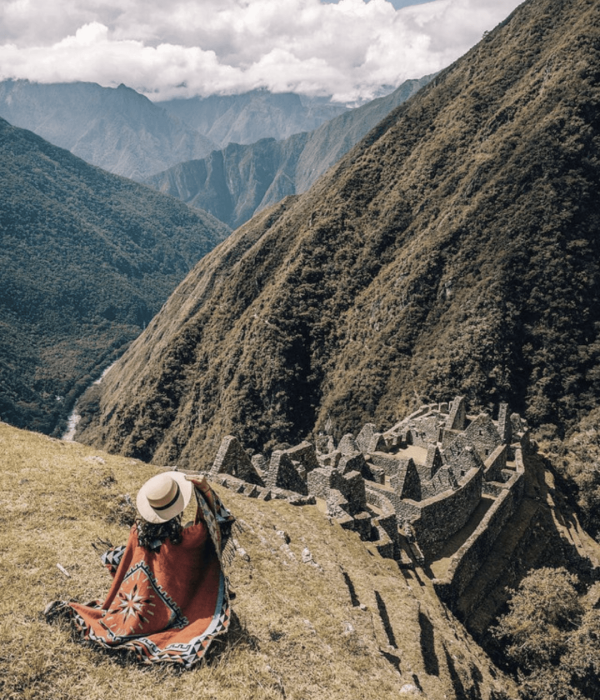 Mujer frente a ruinas incas durante el recorrido del Inca Trail hacia Machu Picchu