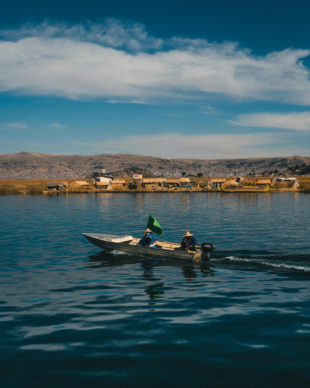 Pequeño bote frente a las islas Uros en el lago Titicaca, el lago navegable más alto del mundo