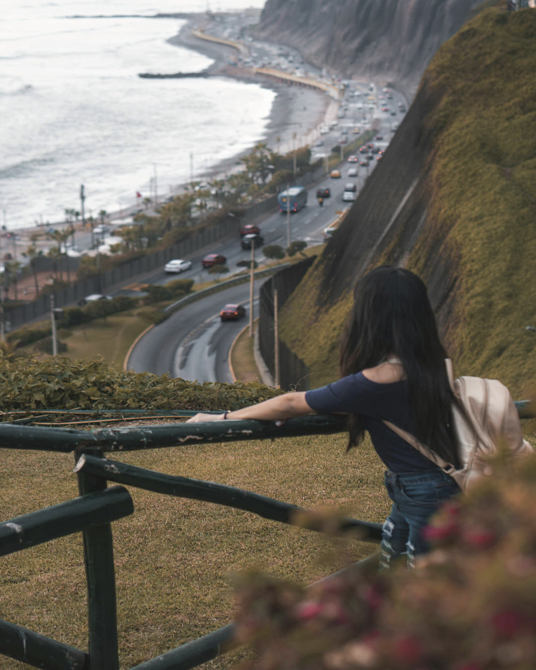 Mujer con mochila en el malecón de Lima con vista al océano Pacífico