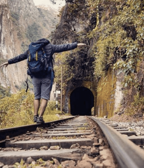 Hombre caminando sobre vías del tren hacia Machu Picchu en ruta menos turística