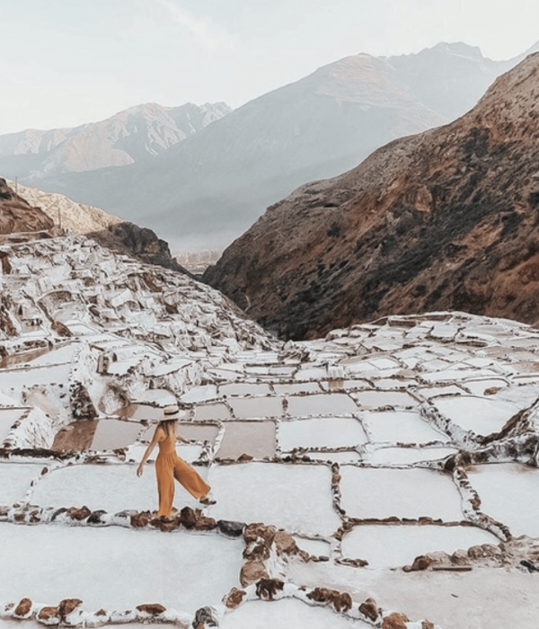 Mujer en las Salineras de Maras con terrazas de sal en el Valle Sagrado