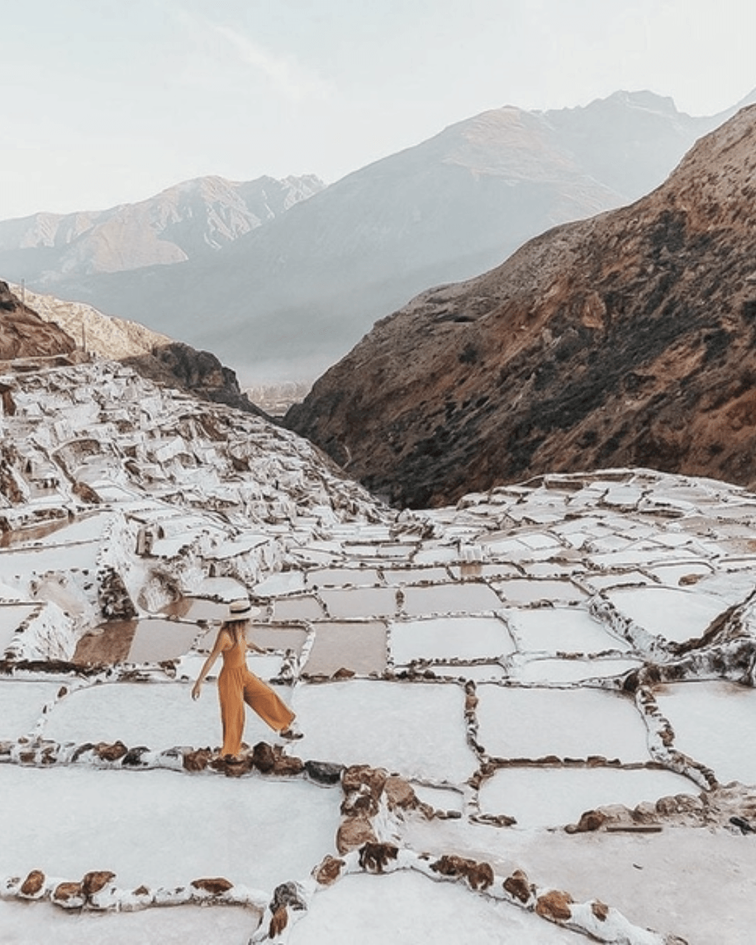 Mujer en las Salineras de Maras con terrazas de sal en el Valle Sagrado
