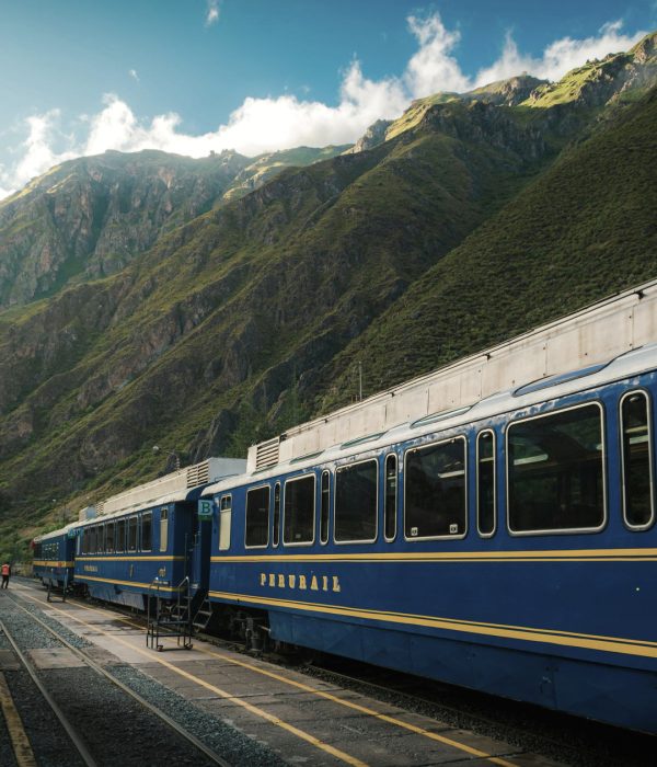 Tren PeruRail recorriendo paisajes verdes andinos en ruta hacia Machu Picchu