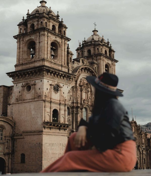 Mujer elegante caminando por el centro histórico de Cusco con arquitectura colonial