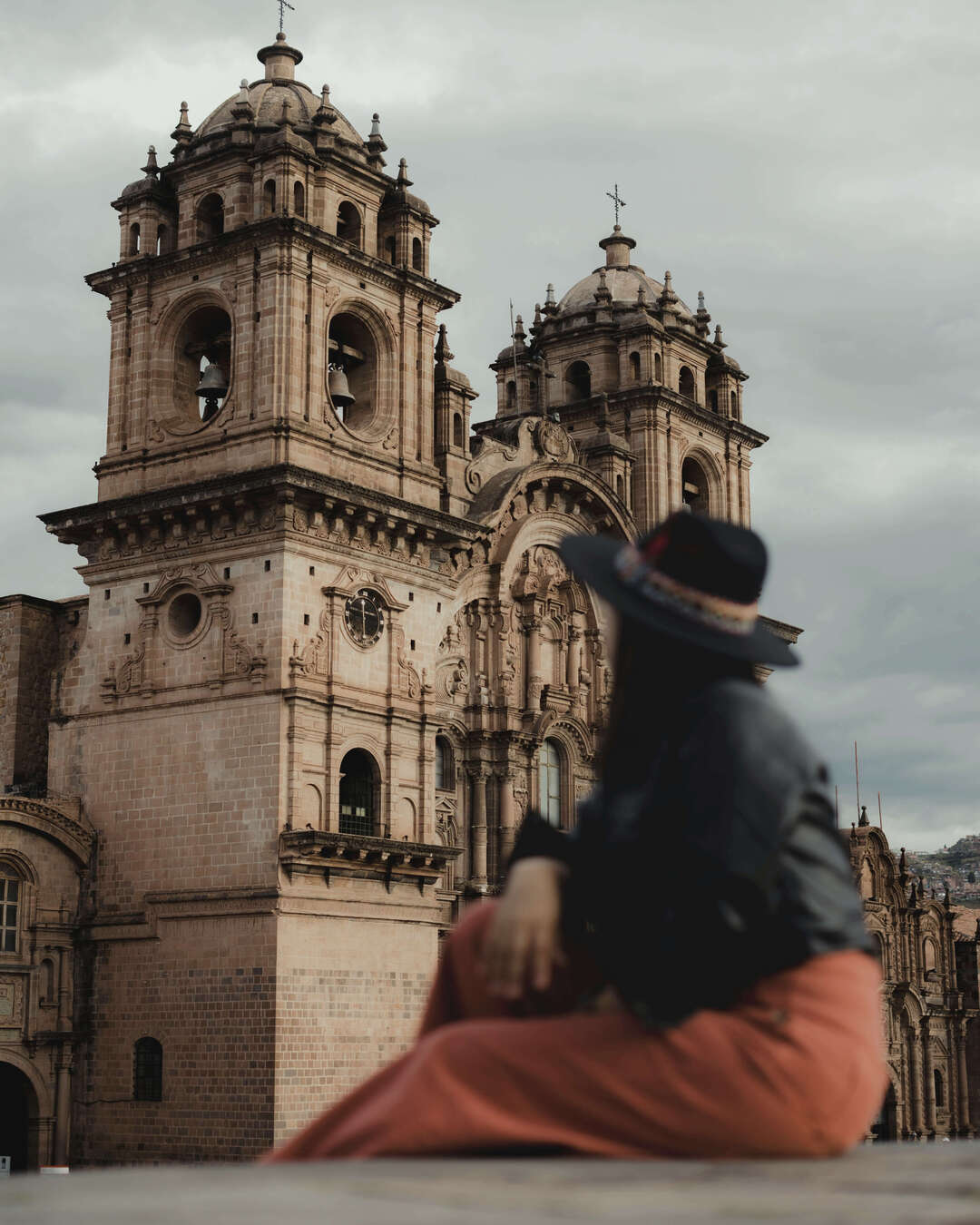 Mujer elegante caminando por el centro histórico de Cusco con arquitectura colonial