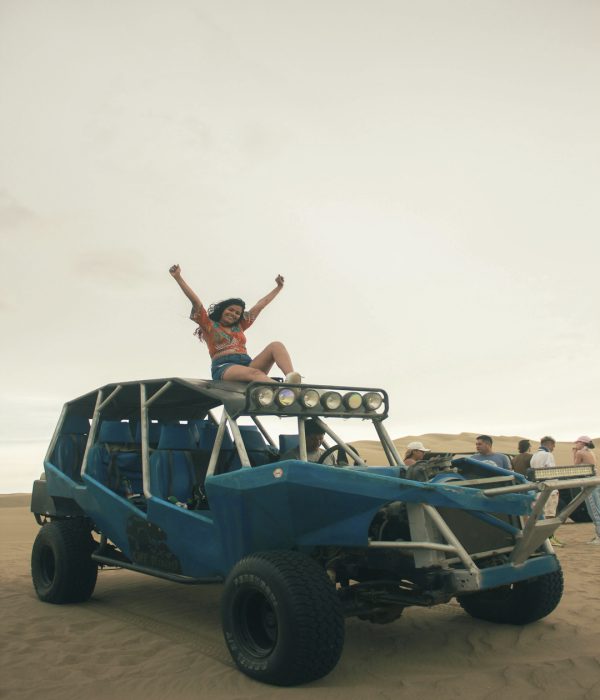 Mujer disfrutando en buggy sobre dunas en el oasis de Huacachina en Perú