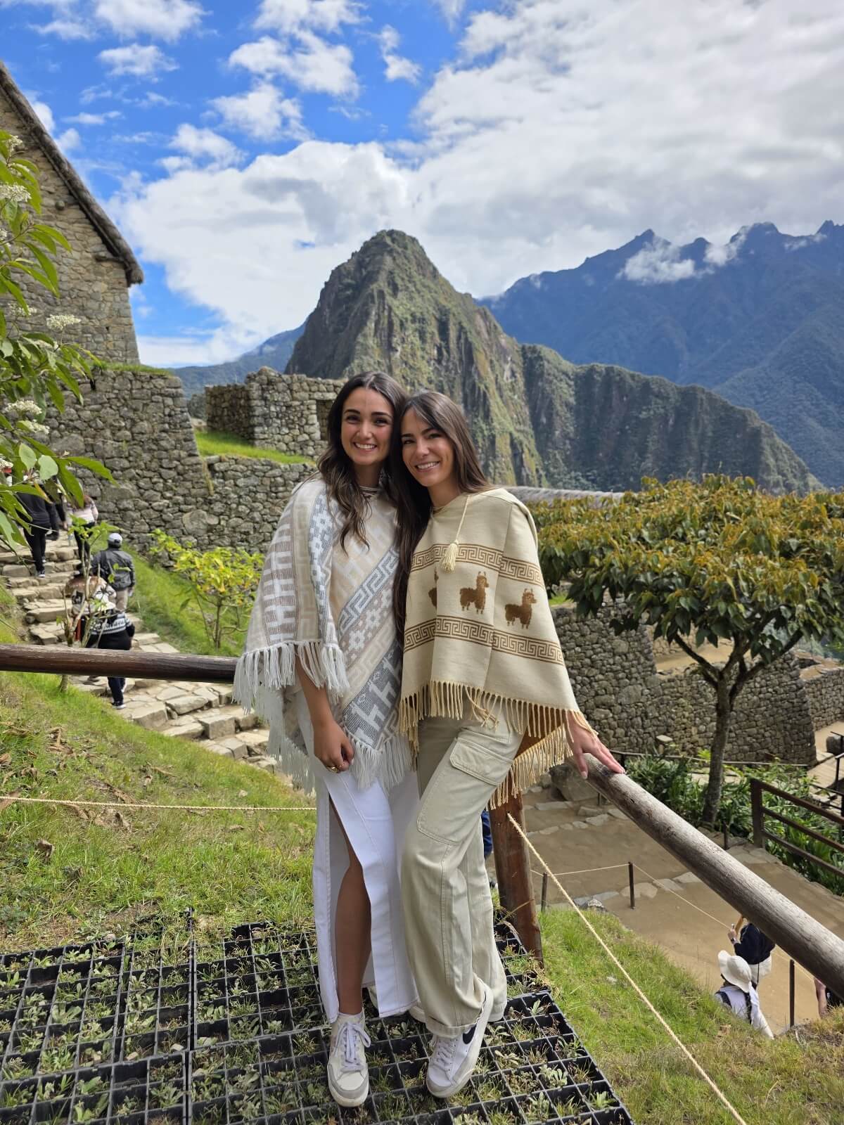 Dos mujeres frente al mirador panorámico de Machu Picchu en el Circuito 1B disfrutando de condiciones climáticas ideales