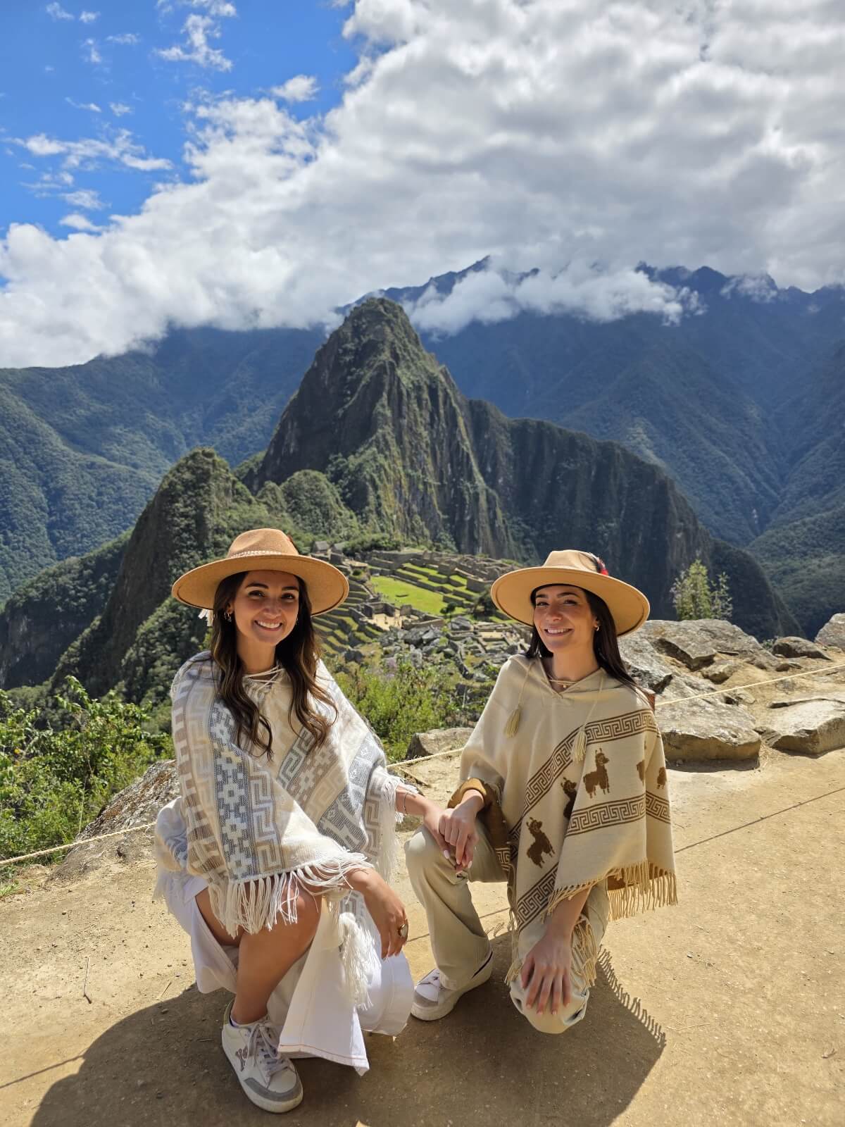 Dos viajeras posando en el punto panorámico del Circuito 1B de Machu Picchu con cielo despejado y excelente visibilidad