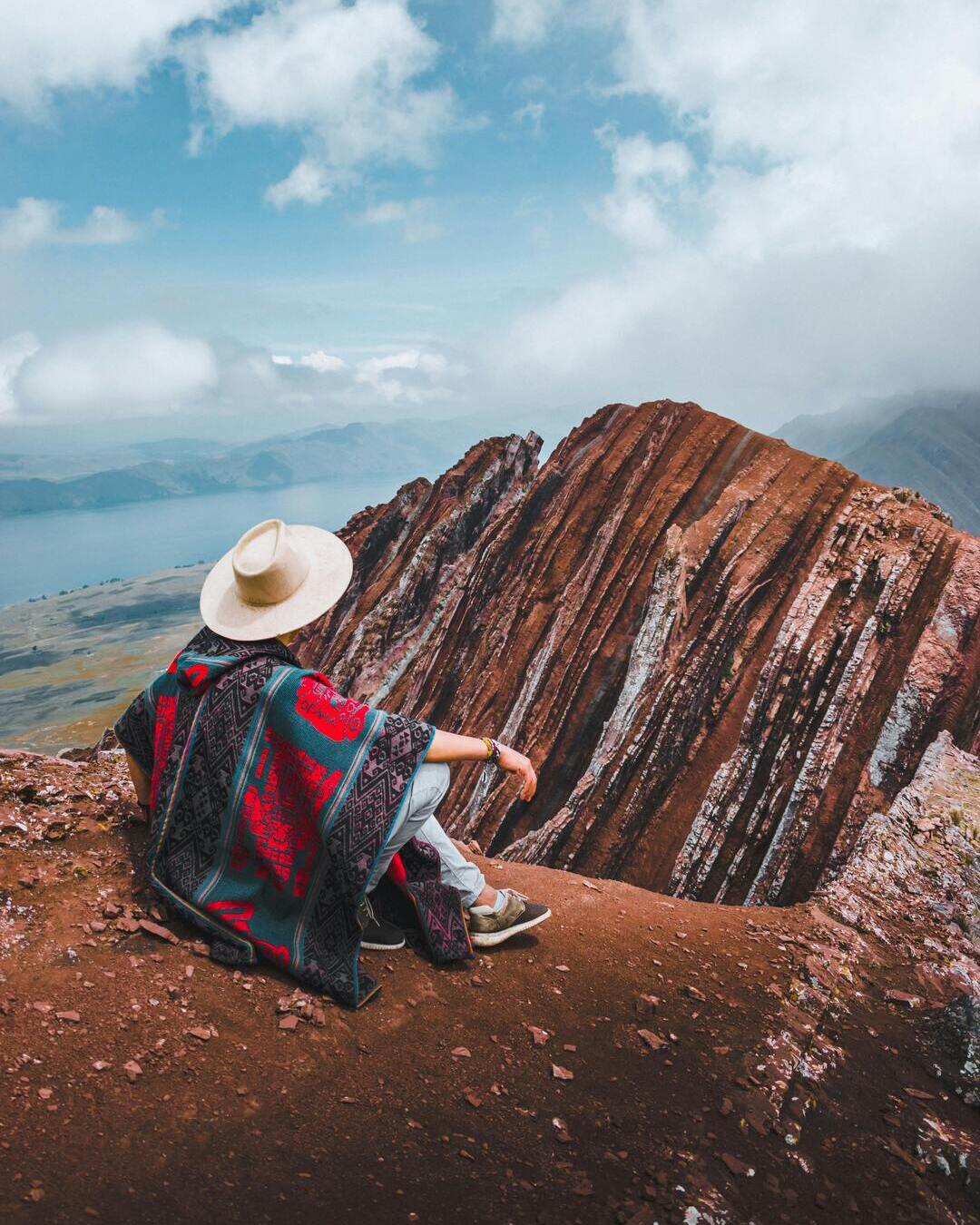 Hombre con un poncho tradicional observando Pallay Punchu, cuyo nombre en quechua hace referencia a un poncho andino por su forma y colores