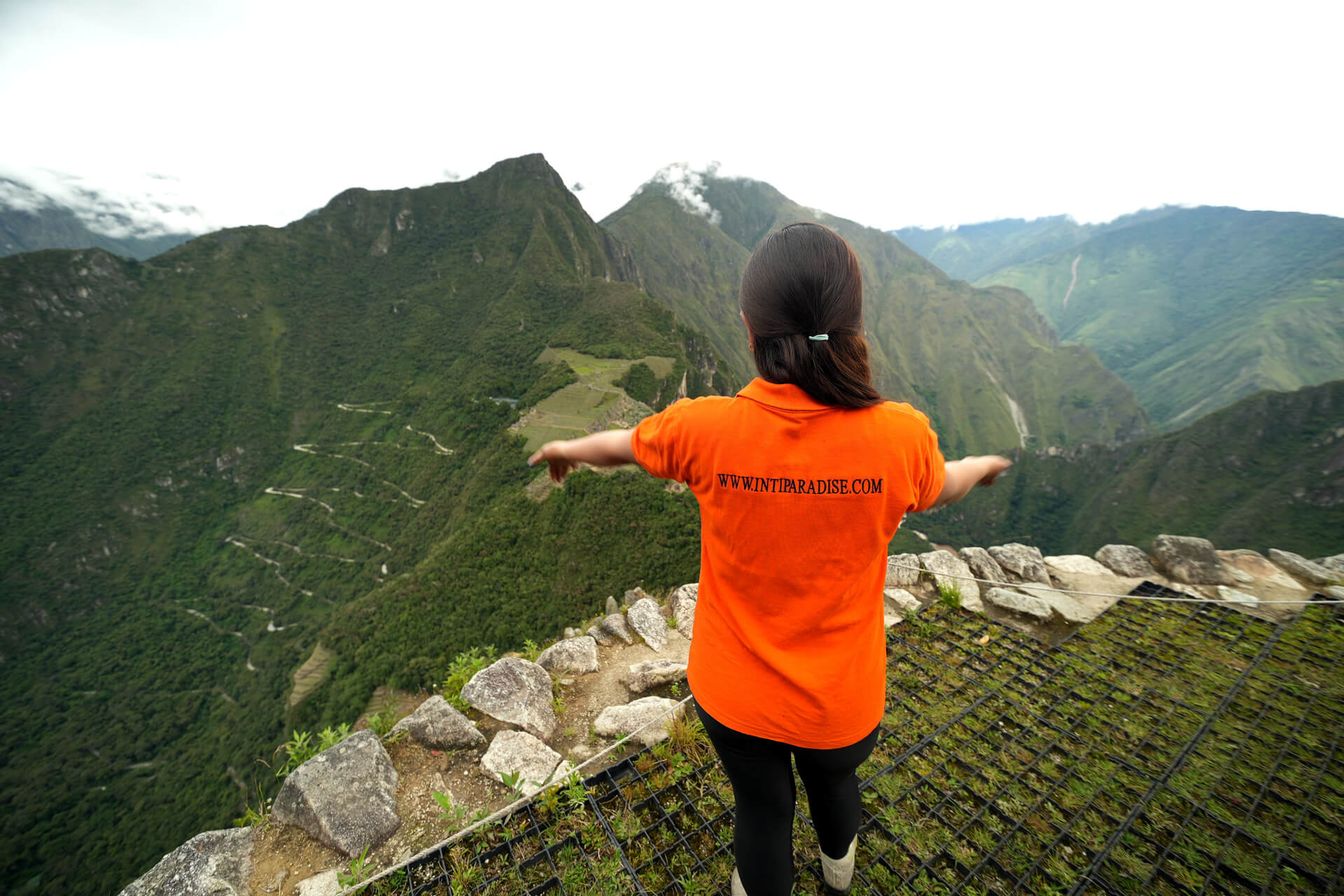 Vista desde la cima de Huayna Picchu con paisaje verde y montañas de los Andes peruanos en el horizonte