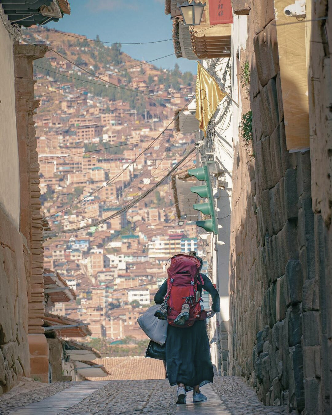 Mochilera caminando por las calles históricas de Cusco, explorando la ciudad entre arquitectura colonial y ambiente andino.