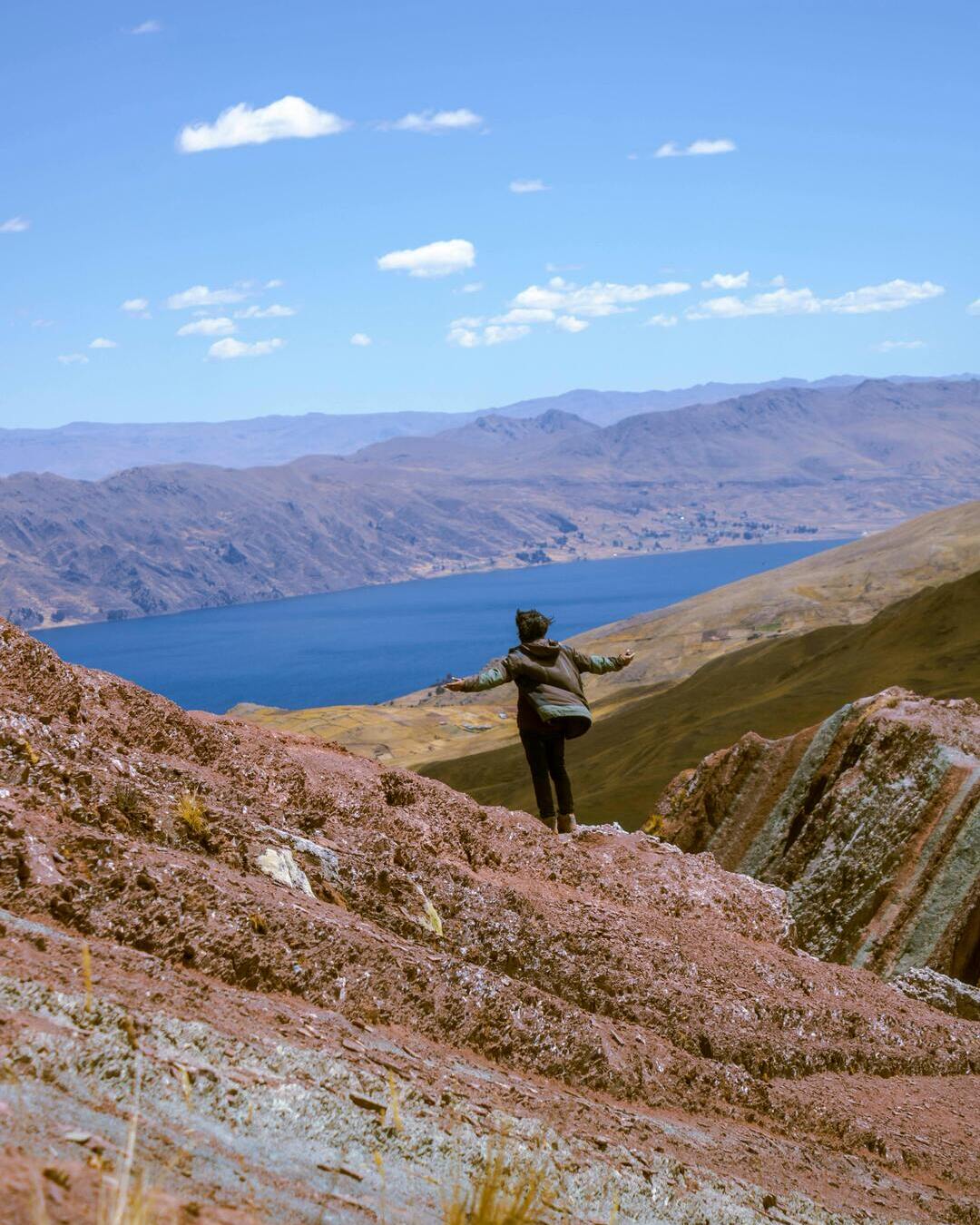 Hombre disfrutando de la vista desde Pallay Punchu a 4700 metros de altura hacia la laguna Langui Layo en Cusco