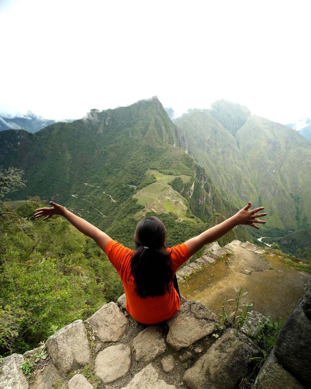 Marilia de Inti Paradise, vista de espaldas, contemplando Machu Picchu desde Huayna Picchu.