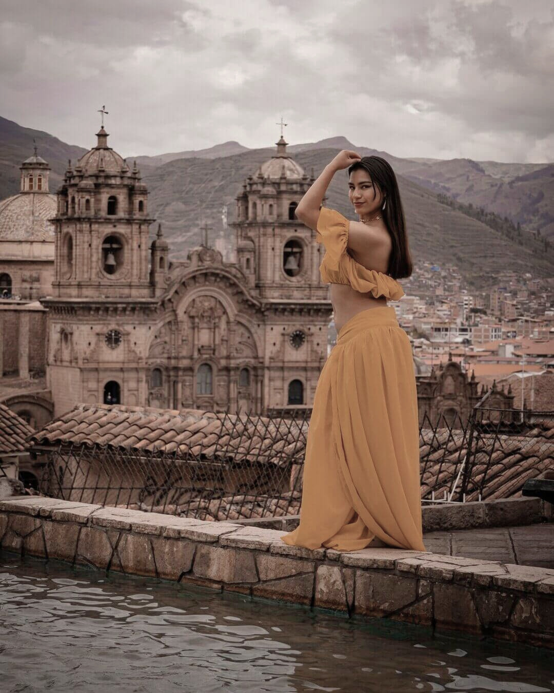 Mujer con vestido en un mirador de Cusco con vista a la Catedral y al Centro Histórico.